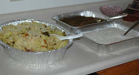 Trays of vegetable fried rice, raita and brinjal curry