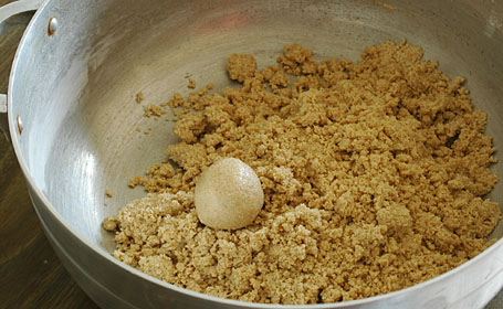 Urad dal-sugar powder and ghee mixture being made into laddus