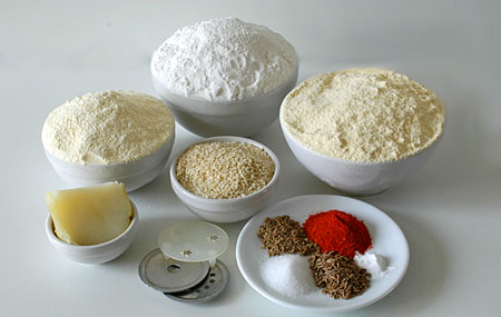 Cooked Potato, Moong flour, Rice flour, Gram flour (besan), sesame seeds, Molds to make different shape murukulu and on the plate Red chilli powder, Ajwan seeds, baking powder, salt and Cumin