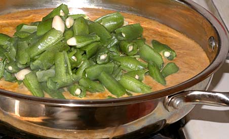 Adding the Indian Broad beans to the curry sauce